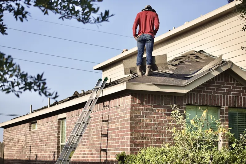 Professional roofer working on a residential roof in Ellerbe Woods